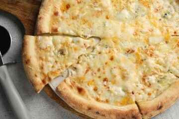 Delicious cheese pizza and cutter on light grey table, flat lay