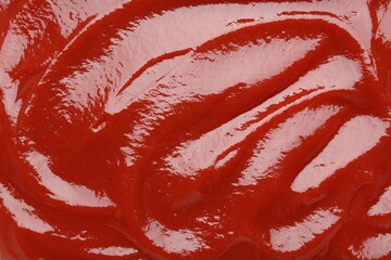 Tasty ketchup as background, top view. Tomato sauce