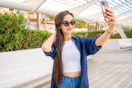 Happy young woman taking selfie in the city