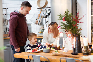 Parents with son and sister in kitchen during Christmas holidays