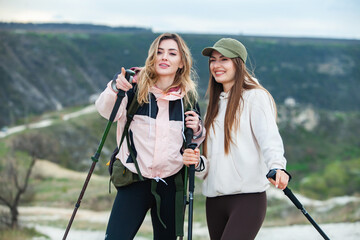 2 friends go on an easy hike in the mountains. Beautiful ladies rest in nature. 
Friendship between...