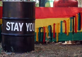 Stay you. White letters. Echoes of Expression. A Message on black  metal barrel against colorful...