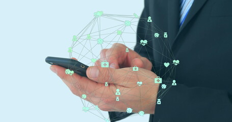 Image of globe of connections with icons over businessman using smartphone