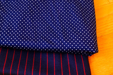 Close-up of fabric with dots and strips pattern for making clothes. Clothing and fabric concept.