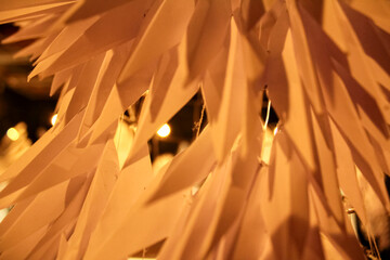 Close-up of the paper decor under the warm tone light. Paper texture, pattern.