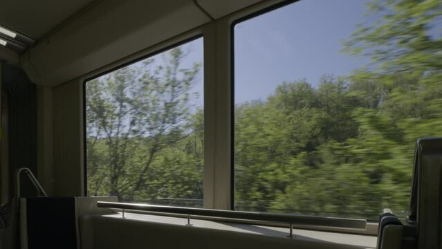 Inside view of the moving train as scenic landscapes pass by outside the windows.