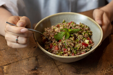 Tabbouleh salad in a bowl on a wooden table .quinoa salad