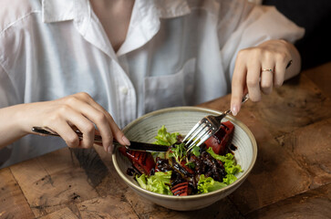 Woman eating salad in a restaurant, close-up. Healthy food. chicken liver salad