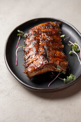Grilled ribs with radish and microgreen on a plate