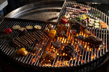 roasted meat and vegetables on the grill with flames and vegetables, close up