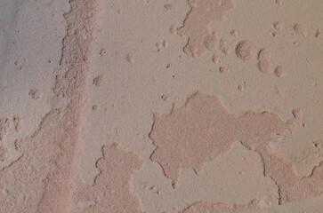 pink colored old building wall surface texture background. the paint layer is peeling and dirty