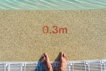 two feet at the pool entrance with a depth indication of 0.3 meters.