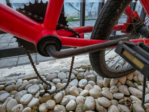 Broken rusty bicycle chain with red frame - Powered by Adobe