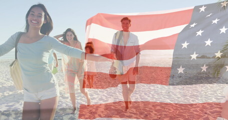 Naklejka premium Composite image of american flag waving against group of caucasian friends enjoying at the beach