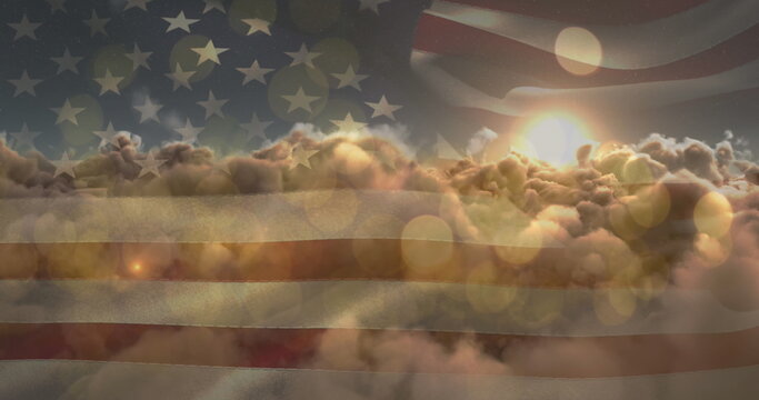 Naklejki Image of glowing spots and sun shining on sky with clouds over american flag