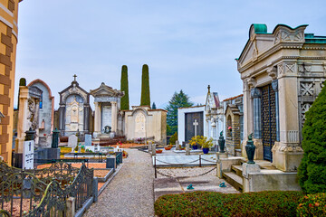 The Cemetery of Sant'Abbondio features rows of tombstones adorned with sculptures, Collina d'Oro,...