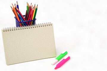 Crayon or colored pencils in box and graph book on white background. Learning, study and...