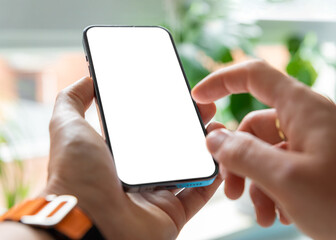 A man is using a smartphone with a blank, frameless  screen in a contemporary home or office...
