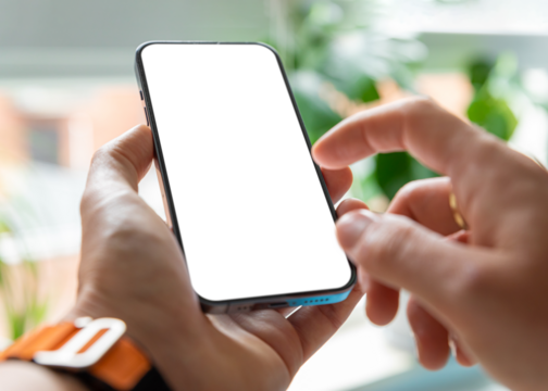 A man is using a smartphone with a blank, frameless  screen in a contemporary home or office interior. Bright light with plants in the background