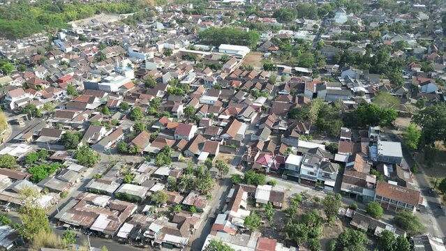 Aerial view of Jogja City with buildings, crowded vehicles traffic in morning sunlight. Sleman cityscape urban landscape. Population density is displacing agricultural land and forests.