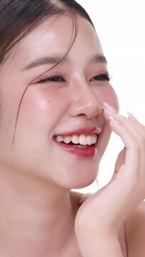 Vertical footage beautiful young Asian woman with healthy facial skin isolated over white background for skincare commercial product advertising. Slow motion shot.