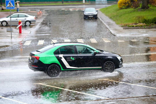 Minsk, Belarus. Apr 6, 2024. Skoda rent car service - Hello driving through puddle during rain, splashing water. Car splashes water, driving on flooded street. Heavy rainfall