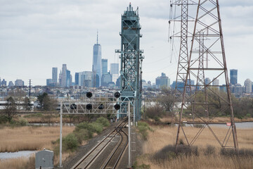 Train tracks lead into the New York New Jersey waterfront on a cloudy day showing urban sprawl and industrial areas