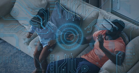 Image of scope scanning and computer circuit board over african american man and his son