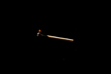 Lit falling match on a black background.