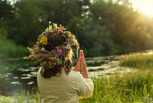 girl in flower wreath outdoor, natural sunny background. rear view. Floral crown, symbol of summer solstice. ceremony for Midsummer, wiccan Litha sabbat. pagan folk holiday Ivan Kupala