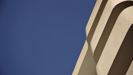 low angle of white facade of minimal building against sky