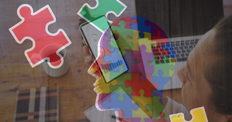 Image of colourful puzzle over caucasian woman with smartphone