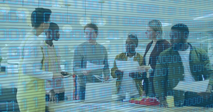 Image of binary code over diverse coworkers talking in office