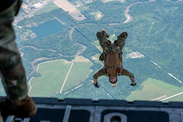 A man is jumping out of an airplane with a parachute