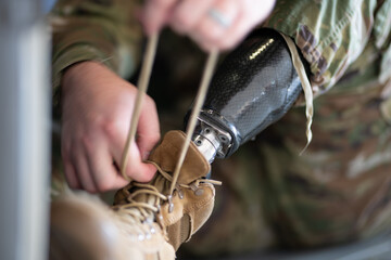 A man with a prosthetic leg is tying his shoe