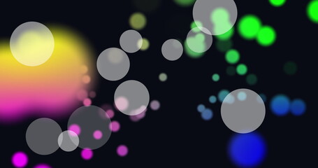 Image of white and colorful spots of light floating against black background