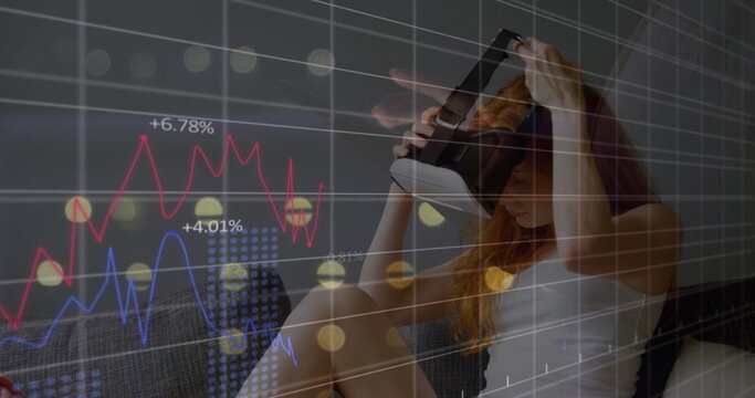Image of financial data processing over caucasian woman using vr headset