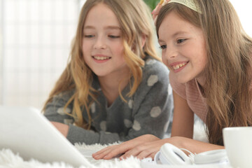 Fototapeta premium Two cute little girls with a laptop