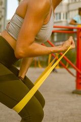 Athletic woman doing sports with elastic bands