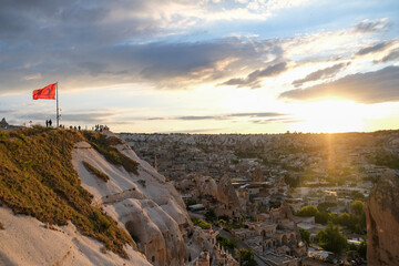 People are watching Cappadocia and sunset from panoramic view terrace. Sunset time and golden hours at Cappadocia.