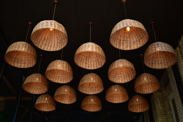 composition of  wicker lampshades with lamps in ta cafe interior