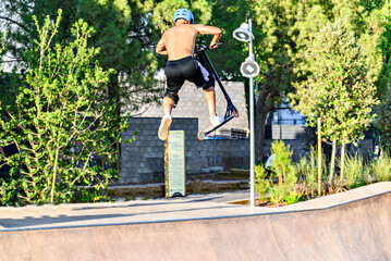 Young man practicing Scootering (Freestyle Scootering) in the new SkatePark of the central park of Igualada, Barcelona, Spain
