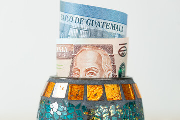 Guatemala money, quetzales banknotes sticking out from a decorative bowl, Financial concept, Financial savings, home budget - 785534823