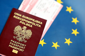 Poland passport of European Union and airlines tickets on blue flag background close up. Tourism...