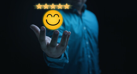 Customer satisfaction concept. Businessman holding five glowing golden stars with smiles icon for...