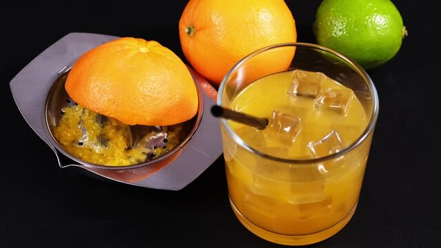 arance lime e bicchiere con spremuta, spremiagrumi con buccia di arancia sul tavolo