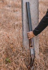 double-barreled shotgun with cartridges, leaning against a pole. Hunting concept