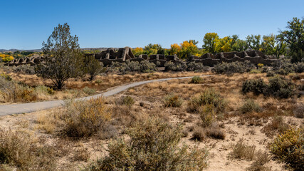 Fototapeta premium Aztec Ruins National Monument in New Mexico. Best preserved Chacoan structures including Aztec West great house built by ancestral Pueblo people. 400 rooms and three stories, autumn cottonwood trees.