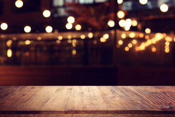 image of wooden table in front of abstract blurred background of restaurant lights - 785540469
