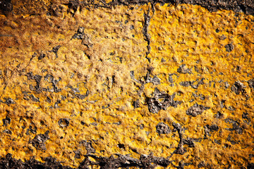 Abstract grunge background of yellow painted asphalt